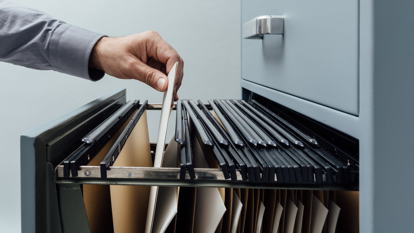 Büro Aktenschrank aus Metall, Mitarbieter sortiert Akten